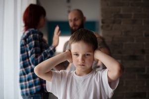 Sad, desperate little boy during parents quarrel
